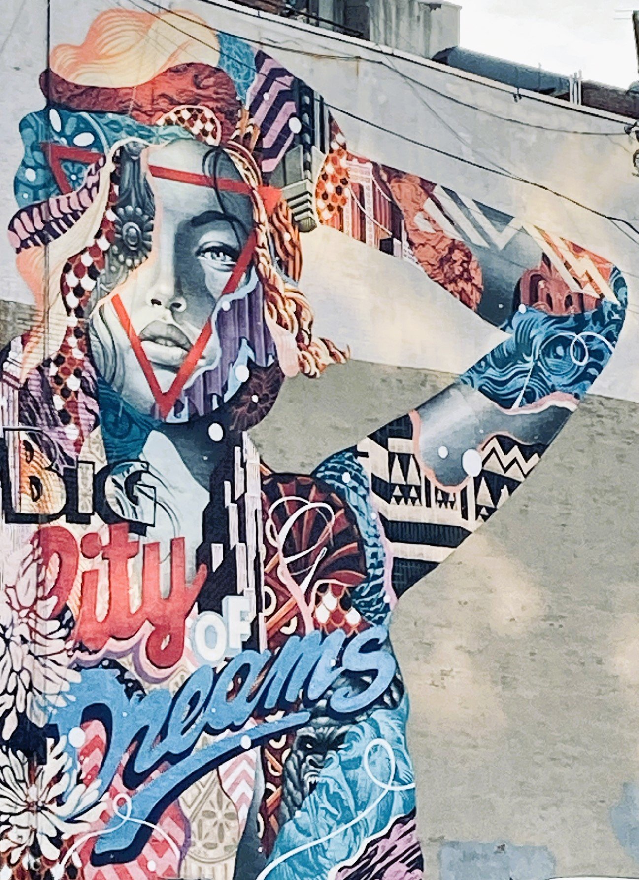 Colorful mural of a woman with "City of Dreams" text